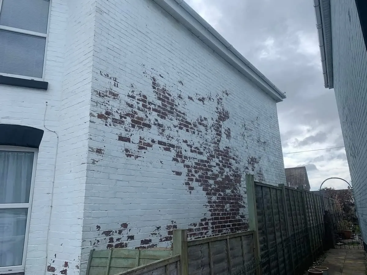 Peeling paint on a brick wall before redecoration in Exmouth